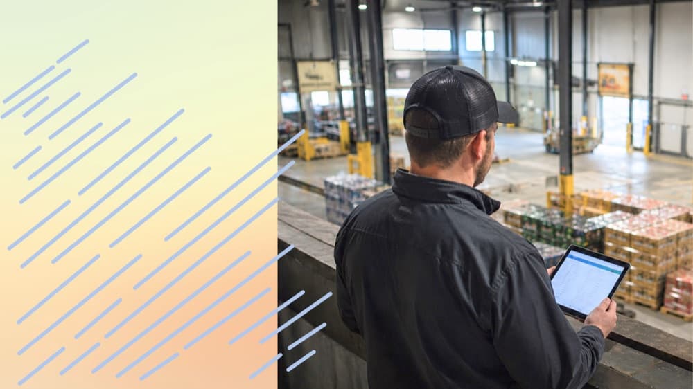 Beverage warehouse worker reviewing forecast on tablet