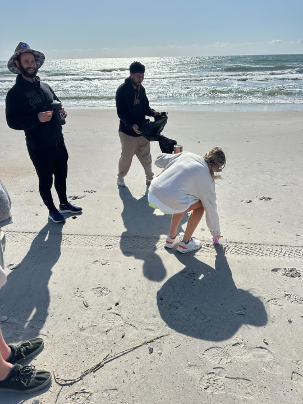 An employee cleaning up the beach on their personalized day